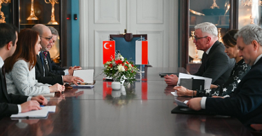Na zdjęciu ludzie siedzący za stołem, na nim flagi Turcji i Polski